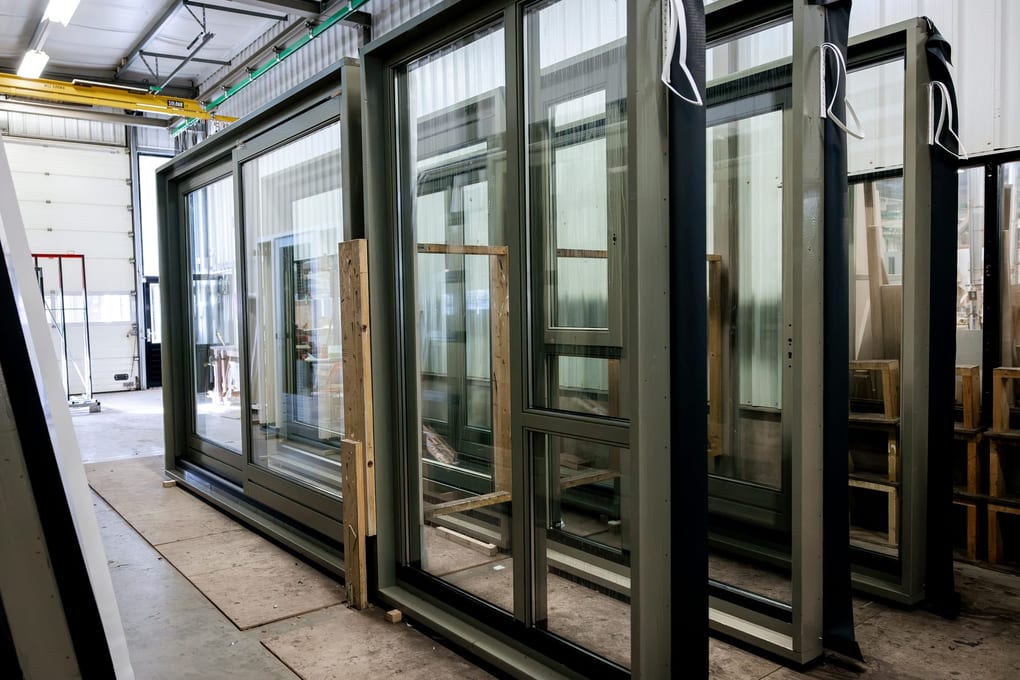 Groen gespoten schuifpuien met glas, klaar voor transport in de hal